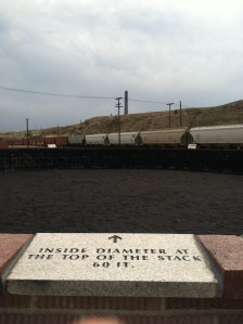 You can see the lone smelter stack in the background next to the electricity pole. In the foreground is a representation of the contents of a smelter stack.